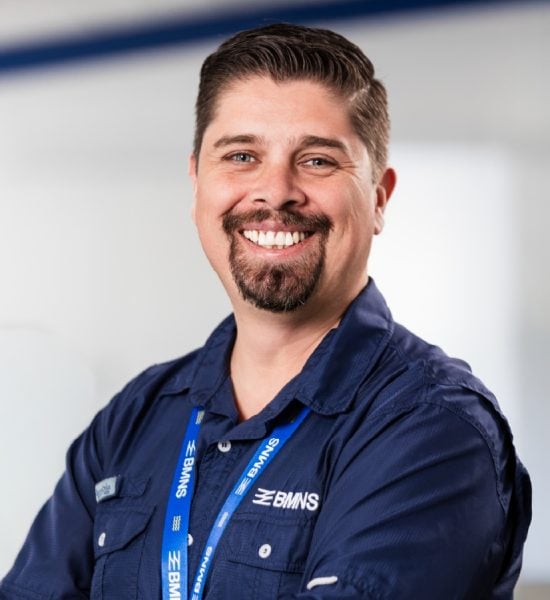 BMNS - Smiling professional with BMNS lanyard and blue shirt